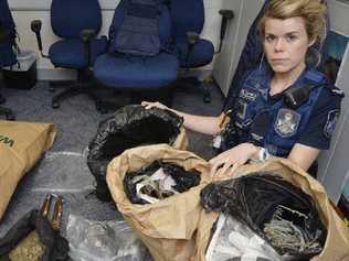 DRUG RAID: Constable Jasmin McCabe with marijuana allegedly found at a Goodna address.