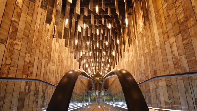 Reclaimed wood framing from construction decorates the travelator between floors. Picture: David Caird