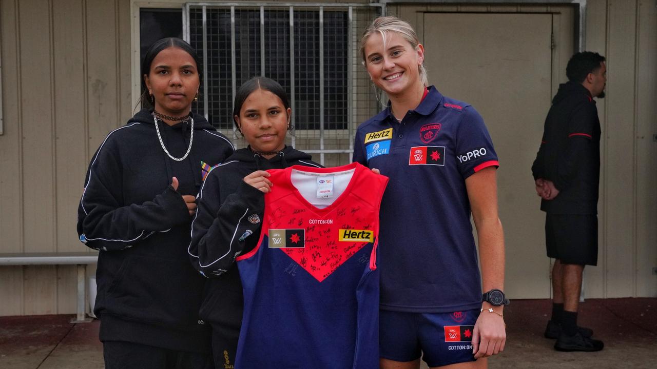 Melbourne AFLW player Lily Johnson presenting a jumper in Santa Teresa ahead of the Alice Springs AFL game between the Demons and Fremantle. Picture: Melbourne Football Club