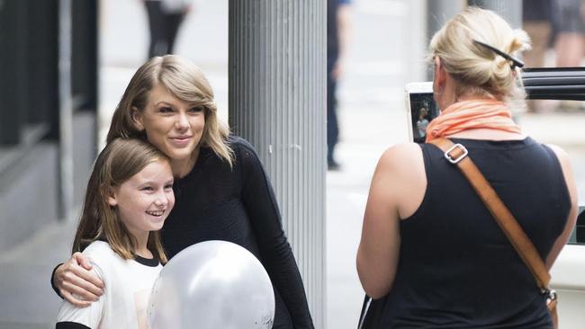 TAYLOR SWIFT LITERALLY STOPS TRAFFIC IN CENTRAL SYDNEY FOR A PHOTO WITH A YOUNG FAN!!TAYLOR SWIFT LEFT HER SYDNEY HOTEL WITH HER SECURITY DETAIL EARLIER TODAY. WHILST TRAVELING THROUGH SYDNEY's SURRY HILLS TAYLOR SPOTTED A YOUNG FAN WEARING A "TAYLOR SWIFT" TSHIRT, AND OBVIOUSLY INSTRUCTED HER DRIVER TO STOP HER CAR, SO THAT SHE COULD JUMP OUT AND MEET HER YOUNG FAN - TAYLOR STOPPED FOR PHOTOS WITH THE LITTLE GIRL BEFORE HEADING OFF AGAIN. EXCLUSIVE 29 November 2015 ©MEDIA-MODE.COM and INF MUST CREDIT: Pictures: Media Mode/INF