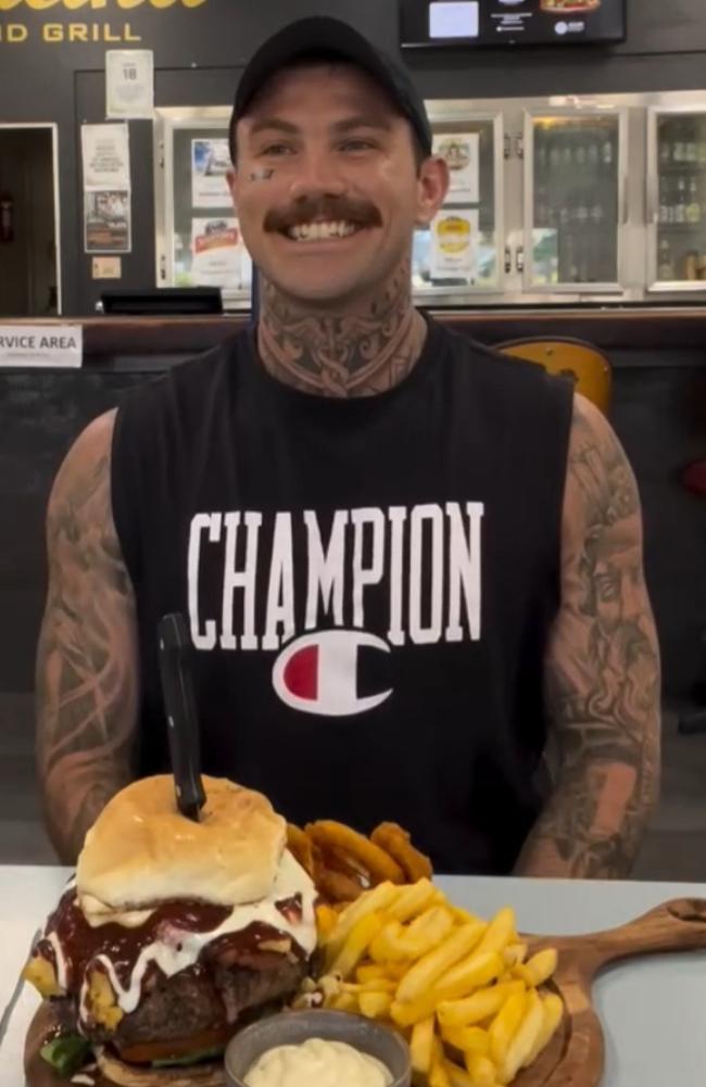 Jimmy Judge taking on a burger challenge at Gladstone Bowls club