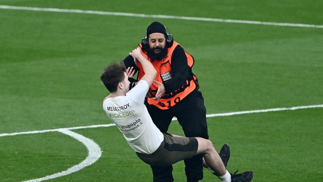 One of the pitch invaders was tackled. Photo by Dan Mullan/Getty Images.