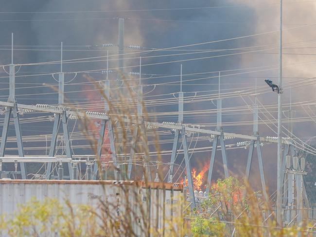 Firefighting aircraft and Firefighters defend Power infrastructure from an out of control fire in Berrimah. Picture: Glenn Campbell Picture: Glenn Campbell