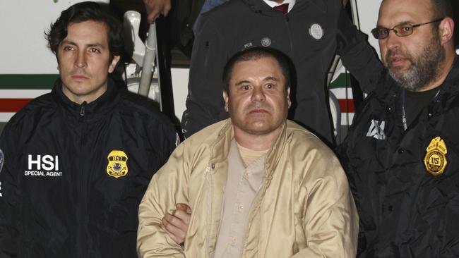 In this Jan. 19, 2017 photo provided by the United States Drug Enforcement Administration, authorities escort Joaquin "El Chapo" Guzman, center, from a plane to a waiting caravan of SUVs at Long Island MacArthur Airport in Ronkonkoma, N.Y. The notorious Mexican drug lord was convicted of drug-trafficking charges, Tuesday, Feb. 12 2019, in federal court in New York. (United States Drug Enforcement Administration via AP, File)