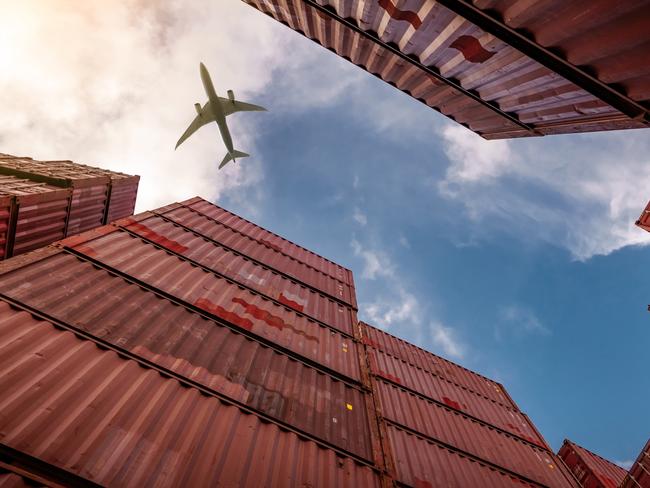 Airplane flying above container logistic. Cargo and shipping business. Container ship for import and export logistic. Logistic industry from port to port. Container at harbor for truck transport.