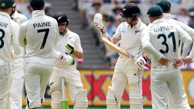 Santner inspects his glove as players wait for the result of the review. Picture: AFP