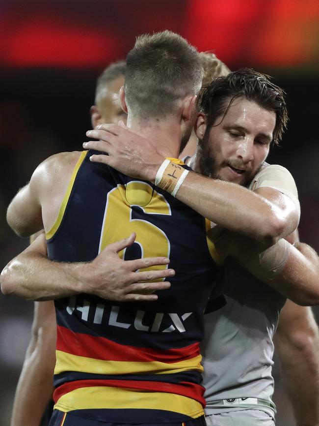 Bryce Gibbs embraces former teammate Dale Thomas after the Adelaide recruit’s first match against his former club. Picture SARAH REED