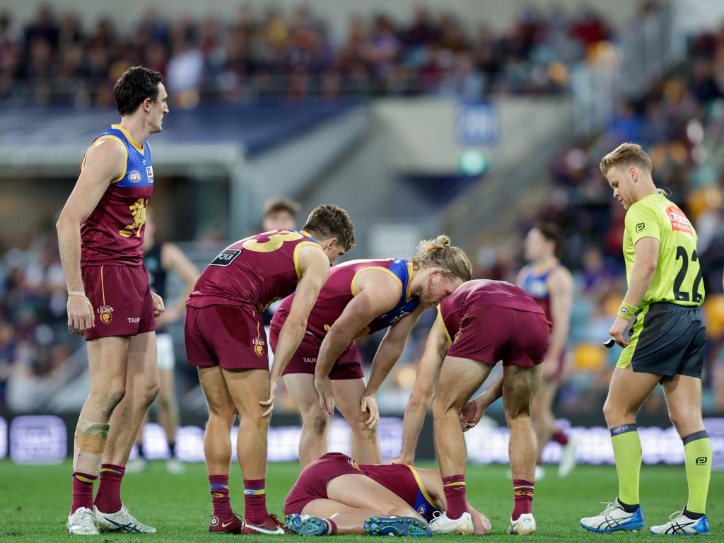 Concerned Lions players surround fallen teammate Marcus Adams. Picture: Russell Freeman/AFL Photos via Getty Images