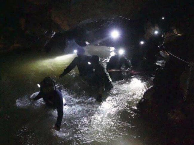 Thai rescue teams walk inside the cave complex where 12 boys and their soccer coach are trapped. Picture: AP