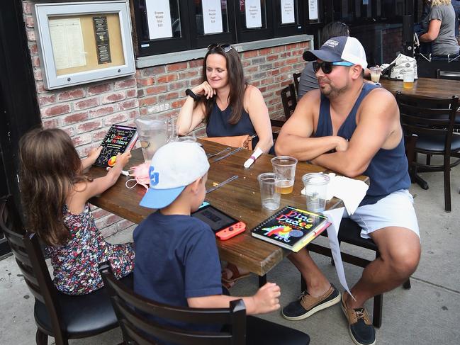 FARMINGDALE, NEW YORK - JUNE 10: The Fuentes family of North Massapequa dine at outdoor seating on Main Street on June 10, 2020 in Farmingdale, New York. Restaurants on Long Island were permitted to open for outside service today as the region entered Phase II of New York State's plan to return to normalcy after closings were mandated due to the coronavirus pandemic.   Bruce Bennett/Getty Images/AFP == FOR NEWSPAPERS, INTERNET, TELCOS & TELEVISION USE ONLY ==