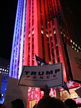 Trump supporters outside the Rockefeller centre that has been lit up by NBC. Madonna held an impromtue concert in New York overnight. Picture: Mark Wilson/Getty Images/AFP.