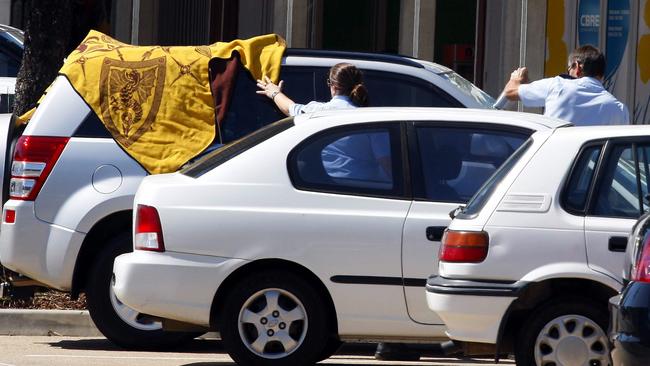 A towel is used to keep a child cool in a car as a policeman smashes the front windscreen to rescue them. 