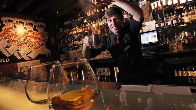 Patrick Cundall makes an Island of Fire cocktail at the Henry Jones Long Bar. Picture: LUKE BOWDEN