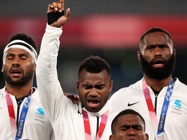 CHOFU, JAPAN - JULY 28: Jerry Tuwai of Team Fiji sings on the podium with his team mates after receiving their gold medals following victory in the Rugby Sevens Men's Gold Medal match between New Zealand and Fiji on day five of the Tokyo 2020 Olympic Games at Tokyo Stadium on July 28, 2021 in Chofu, Tokyo, Japan. (Photo by Dan Mullan/Getty Images)