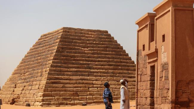 In this Thursday, April 16, 2015 photo, a Sudanese tour guide and a member of the security forces observes a temple at the Meroe pyramids site, in al-Bagrawiya, 200 kilometers (125 miles) north of Khartoum, Sudan. The pyramids at Meroe are deserted despite being a UNESCO World Heritage site like those at Giza in Egypt. (AP Photo/Mosa'ab Elshamy)