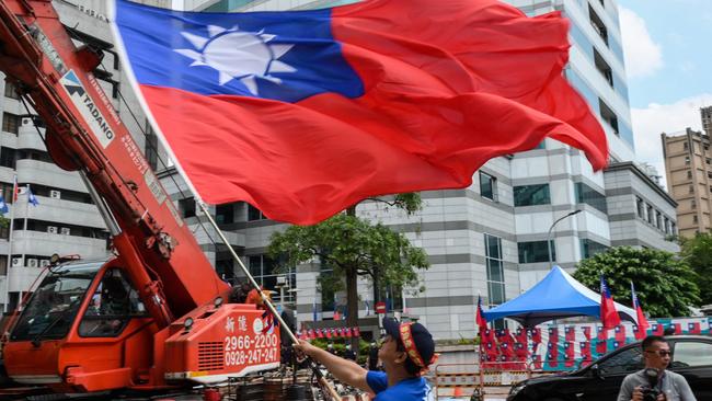 A supporter of the main opposition Kuomintang (KMT) waves a Taiwanese flag during a rally outside the KMT headquarters.