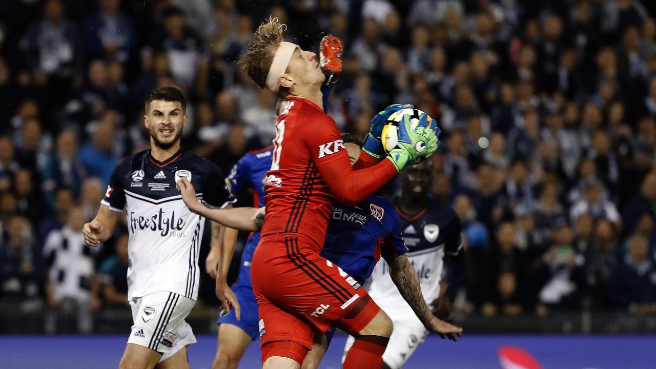 Newcastle Jets Roy O'Donovan attempts to kick the ball mid air but kicks Melbourne Victory's Lawrence Thomas in the head