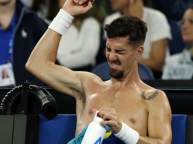 MELBOURNE, AUSTRALIA - JANUARY 15: Thanasi Kokkinakis of Australia reacts as he stretches his shoulder during a medical time-out in the Men's Singles Second Round match against Jack Draper of Great Britain during day four of the 2025 Australian Open at Melbourne Park on January 15, 2025 in Melbourne, Australia. (Photo by Daniel Pockett/Getty Images)