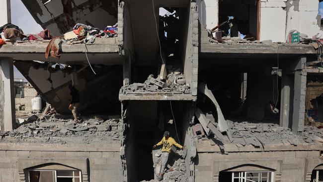 A Palestinian youth inspects the damage inside a destroyed building following Israeli bombardment of Rafah's Tal al-Sultan district on Tuesday. Picture: AFP