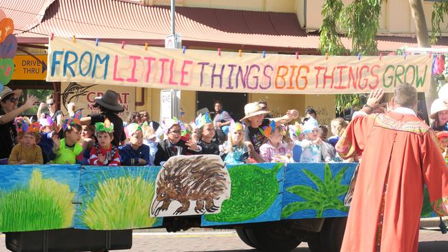 Mayor Matt Paterson waves to schoolchildren in their float at the annual parade.