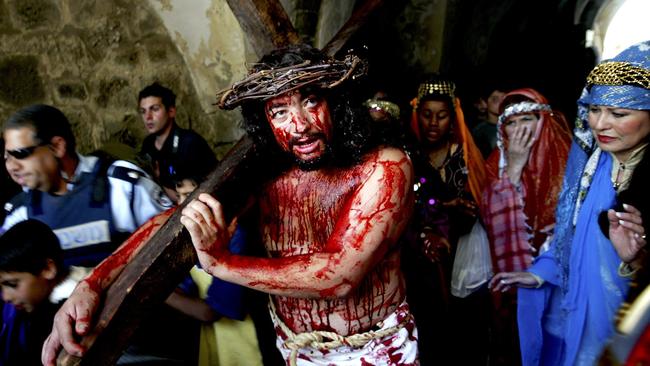 Wearing a crown of thorns, a pilgrim from California physically re-enacts the Passion of Christ carrying the cross up the Via Dolorosa in east Jerusalem's Old City. Picture: AP