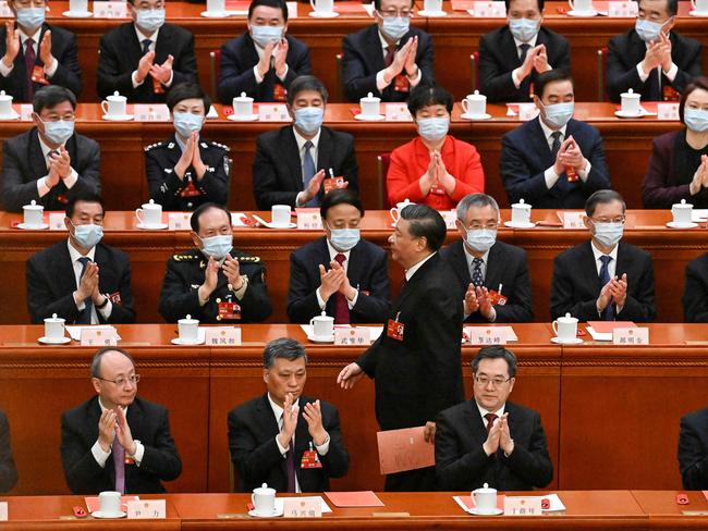 China's President Xi Jinping walks past delegates as he prepares to vote during the third plenary session of the National People's Congress (NPC). Picture: AFP