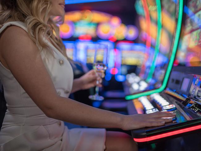 beautiful girl drinking wine alone at casino poker machine pokies istock generic