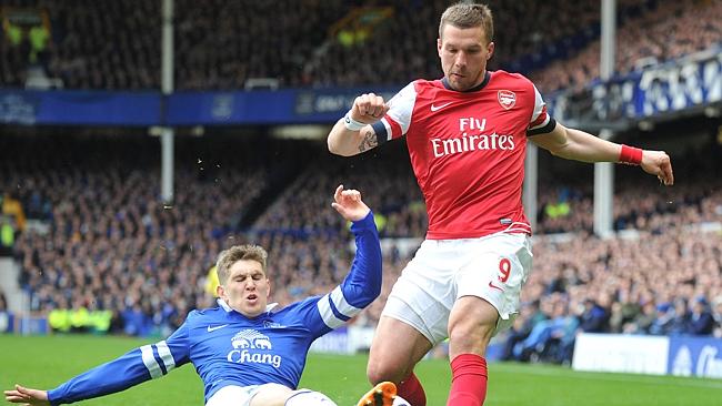 Everton&#39;s defender John Stones (left) slides in to tackle Arsenal&#39;s striker Lukas Podolsk