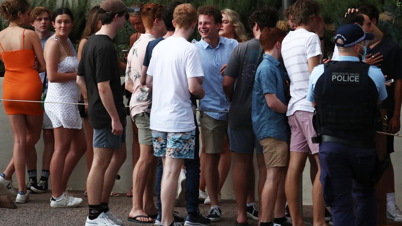 Schoolies wait in line outside the Beach Hotel, Byron Bay while police monitor the crowd. Picture: Jason O'Brien