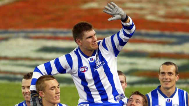 Jason McCartney is chaired off the ground after his comeback (and retirement) game by Adam Simpson, Drew Petrie, Shannon Grant and Sahnnon Watt. Kangaroos v Richmond. Telstra Dome. Digital Image.