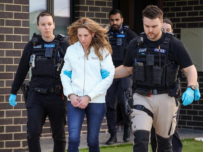 Police take a woman into custody after a raid on a St Albans house. Picture: Ian Currie