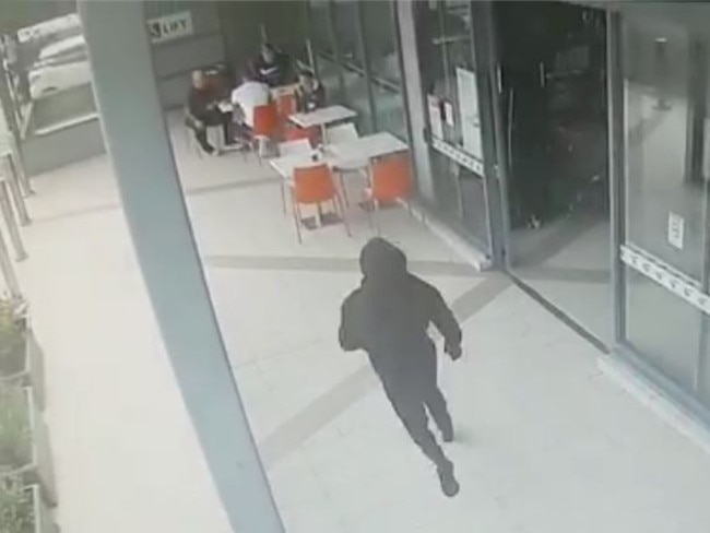 CCTV shows a hooded figure approach Walid Ahmad at Centro Bankstown.