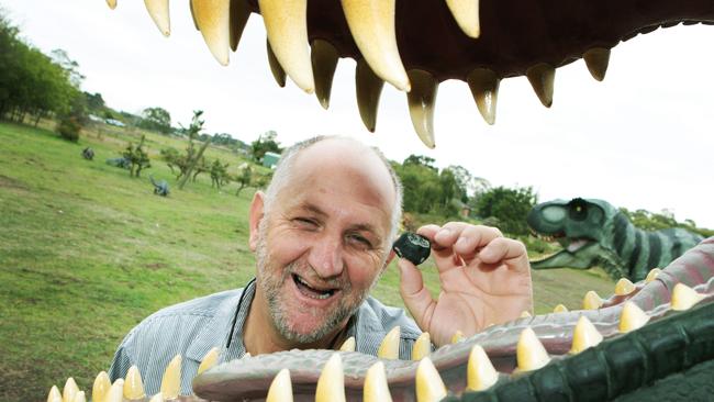 Crystal World owner Tom Kapitany (pictured holding a rare piece of Russia's Chelyabinsk meteor), in the dinosaur garden he planned to put the model Australotitan in.