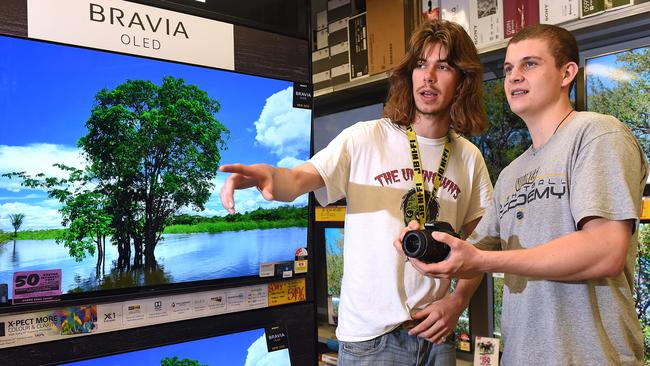 JB Hi-Fi staff member talks to customers in Sunnybank. Picture: AAP/ John Gass.