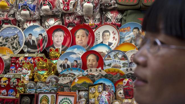 Souvenirs of China, including plates bearing the likeness of Mao Zedong and Xi Jinping, on display at a market stall in Beijing. Picture: Getty Images