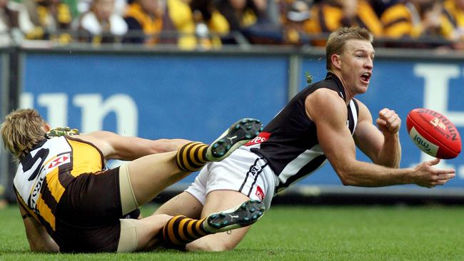 Nathan Buckley gets a handball clear from Sam Mitchell during a clash at Marvel Stadium in 2006. Mitchell will soon follow in Buckley’s shoes by coaching his own club.