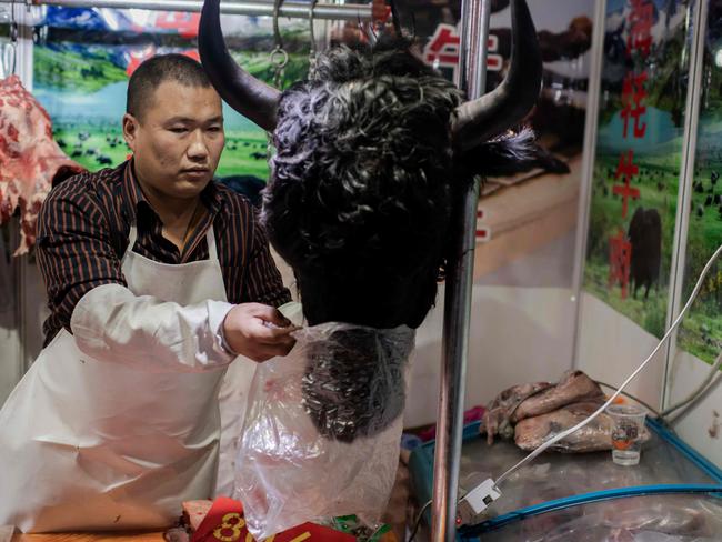 This picture taken on January 15, 2020 shows a butcher selling a yak's head at a market in Beijing. Picture: Nicolas Asfouri/AFP