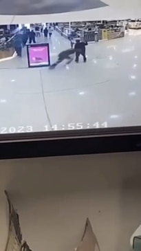 A man tackling another man in a local shopping centre