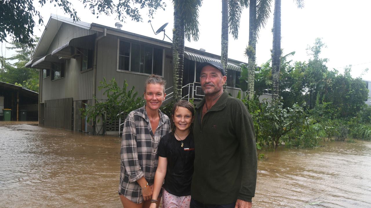 Mossman St residents Brenda, Mick and Indi Burford in front of their flooded house in Mossman. Picture Peter Carruthers