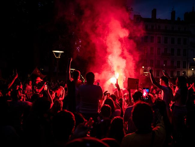 Left wing supporters light red flares as they celebrate during a rally. Picture: AFP