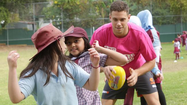 GWS Giants midfielder Josh Kelly teaches kids some passing skills at Bankstown West Public School. Picture: Timothy Clapin