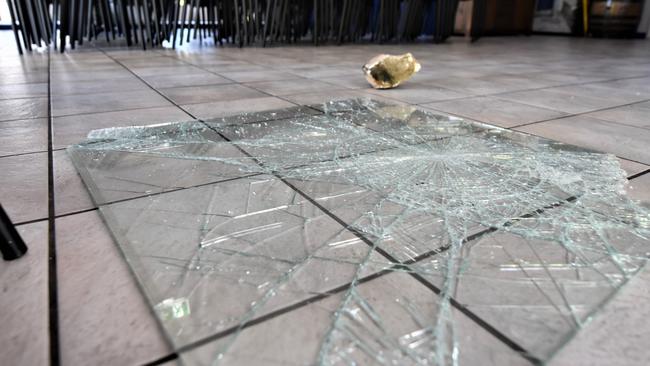 A rock and broken panel of glass left at the restaurant after Monday’s break in. Picture: Natasha Emeck