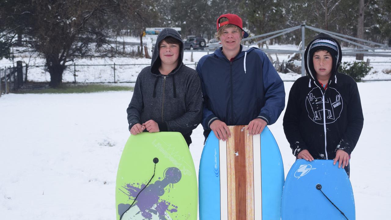 Kyle and James Garth with Hayden Riley 'boogie boarding' in the snow at Wallangarra. Photo: Alex Nolan / Stanthorpe Border Post