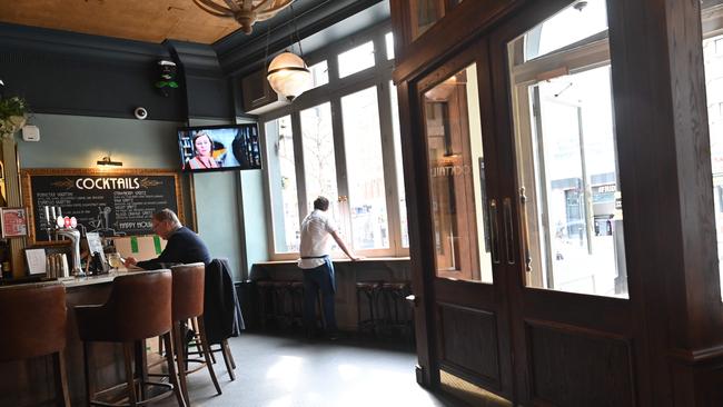 A barman cuts a lonely figure at his near-empty pub in central London after the government announced stringent social distancing advice. Picture: AFP