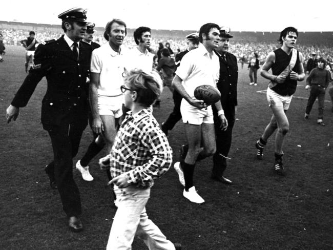 Umpire Bill Deller has to be escorted from the ground by police officers after a clash between Collingwood v Richmond. A job not for the faint-hearted in the 1970s.