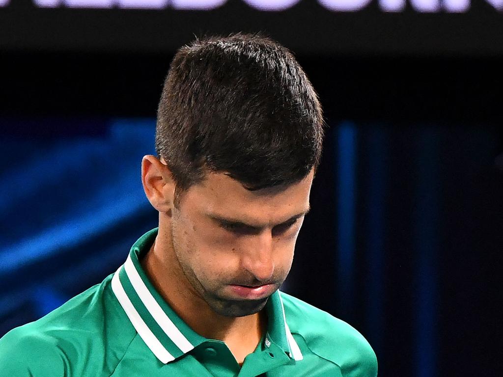 (FILES) This file photo taken on February 12, 2021 shows Serbia's Novak Djokovic reacting while playing against Taylor Fritz of the US during their men's singles match on day five of the Australian Open tennis tournament in Melbourne. - Novak Djokovic lost his bid to avoid deportation from Australia on January 16, 2022, with a Federal Court unanimously rejecting his appeal to stay in the country and defend his Australian Open title. (Photo by William WEST / AFP) / -- IMAGE RESTRICTED TO EDITORIAL USE - STRICTLY NO COMMERCIAL USE --