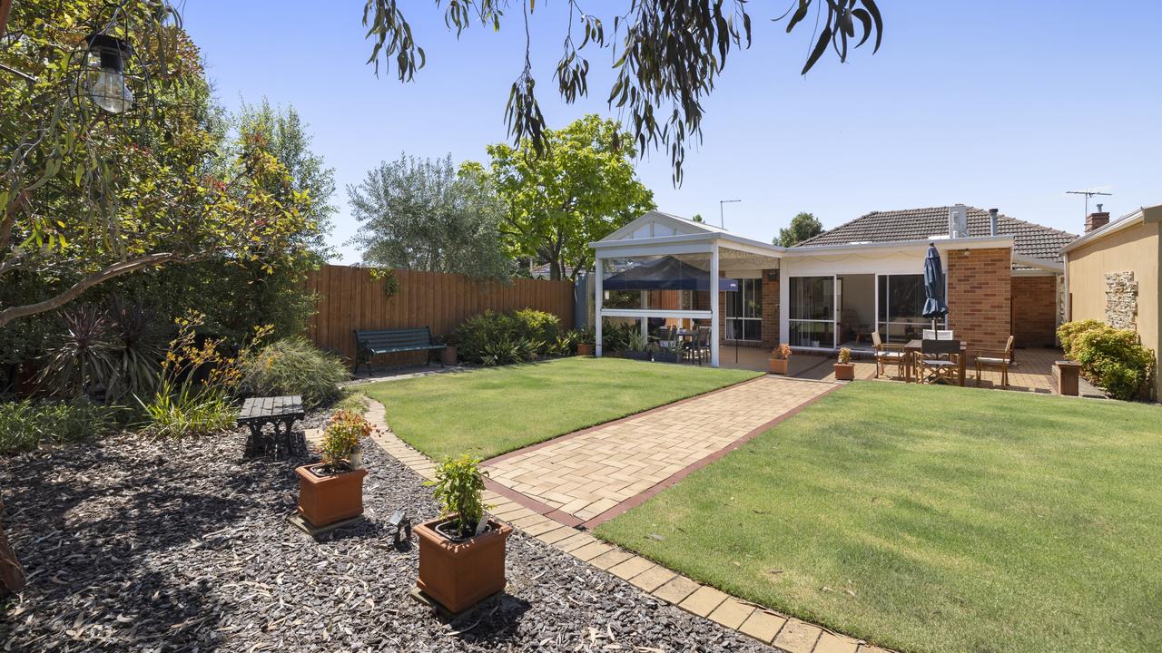 The expansive backyard with a manicured lawn.