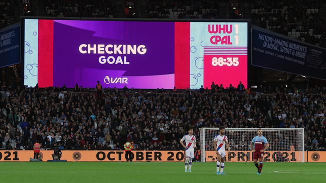 The players wait as VAR review, displayed on screen, takes place during the Premier League match between West Ham United and Crystal Palace at London Stadium on October 05. Picture: Catherine Ivill/Getty Images