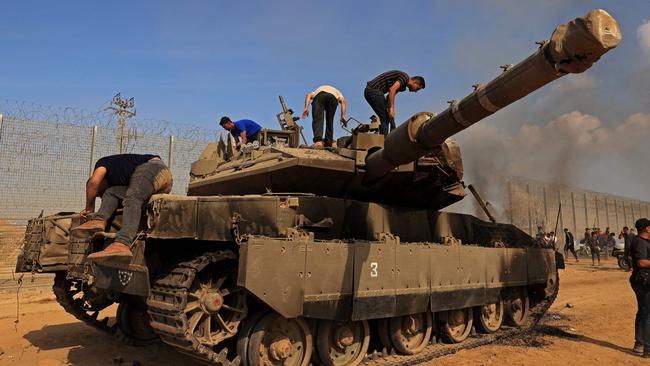 Palestinians take control of an Israeli tank after crossing the border fence with Israel on October 7. Picture: AFP