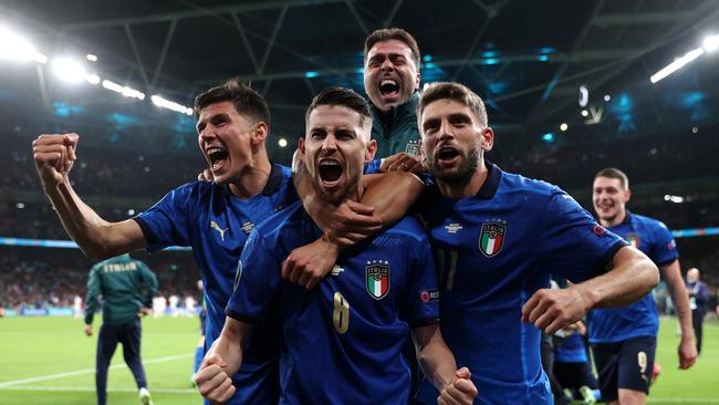 Jorginho of Italy celebrates with Matteo Pessina and Domenico Berardi after scoring their sides winning penalty in the penalty shoot out during the UEFA Euro 2020 Championship Semi-final match between Italy and Spain at Wembley Stadium.